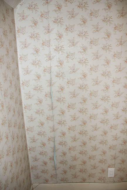 The wallpaper peeling off the wall.