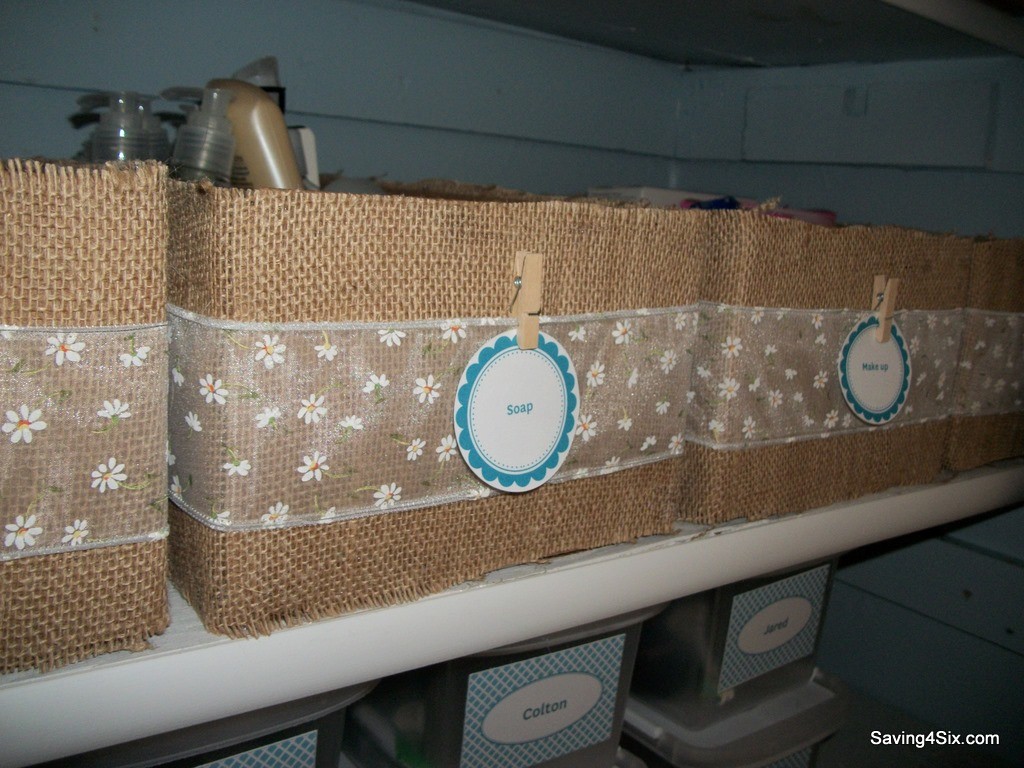 Burlap wrapped boxes with a clothespin on the front holding the bin label.