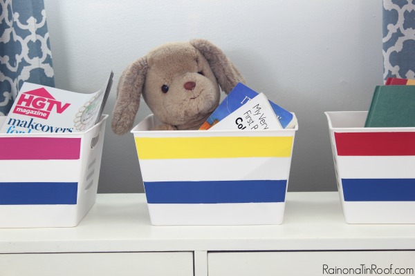 Colour coded bins with a teddy bear in one and magazines in another.
