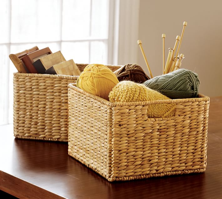 Woven baskets with yarn and knitting needles in it.