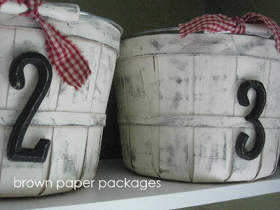 Apple baskets white washed painted with numbers on the front of them.