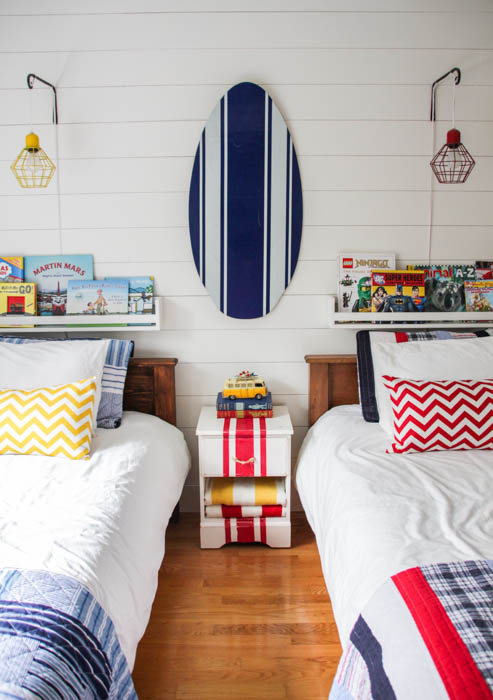 Nautical Camp Style Boys Bedroom with a blue and white boogie board on the wall.