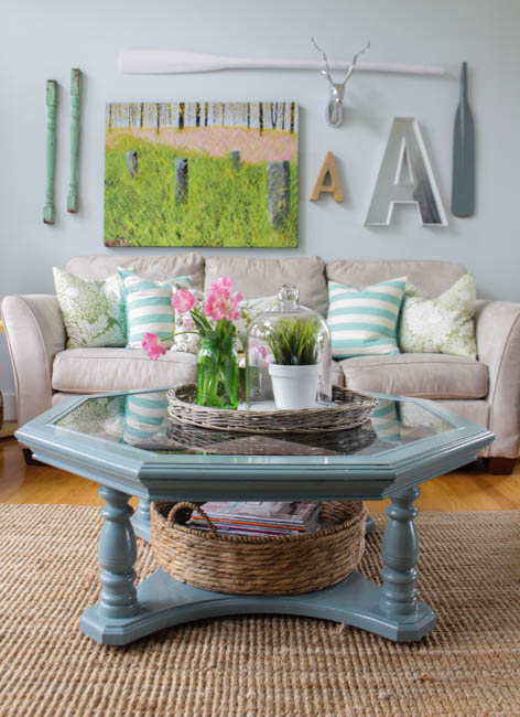A blue octagon table has a spring vignette on it.