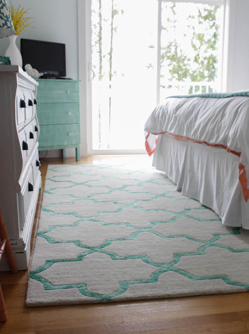 A white and aqua rug in the bedroom.