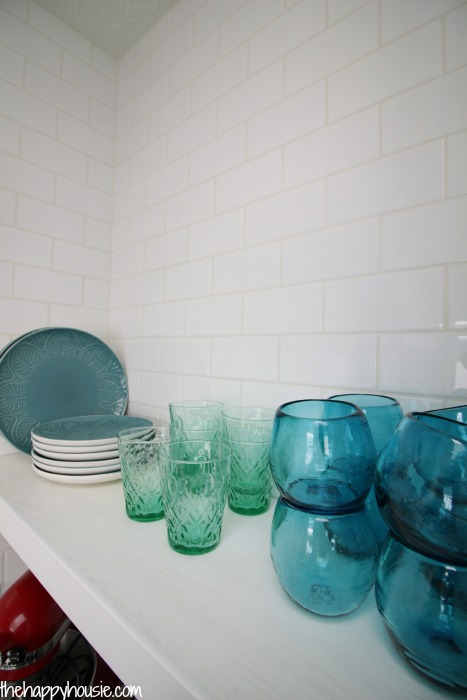 Blue coloured glass on a white shelf in the kitchen.