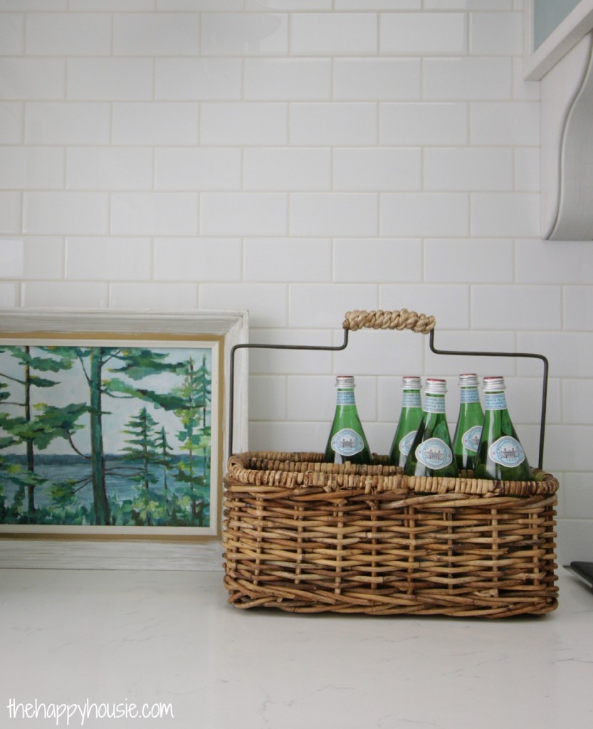 Subway tile in the kitchen with a painting in front of it.