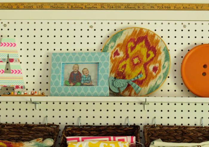 A picture of two boys laughing in a frame on the pegboard shelf.