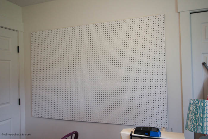 The pegboard hanging on the wall in the craft room.