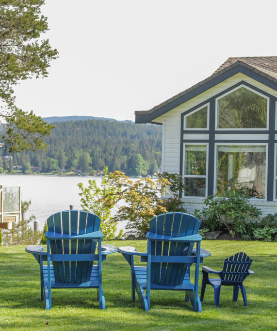 Two large blue chairs and one small child size chair on the lawn.