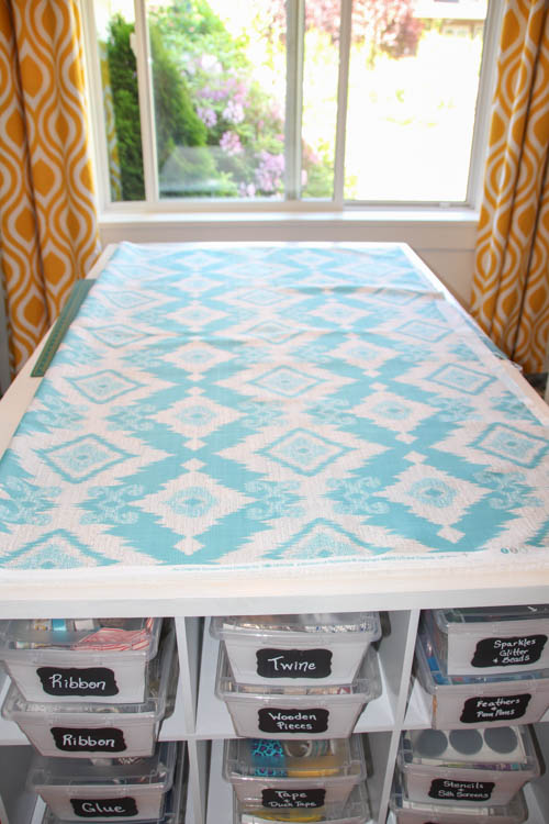 Blue and white fabric laid out on a table for cutting.