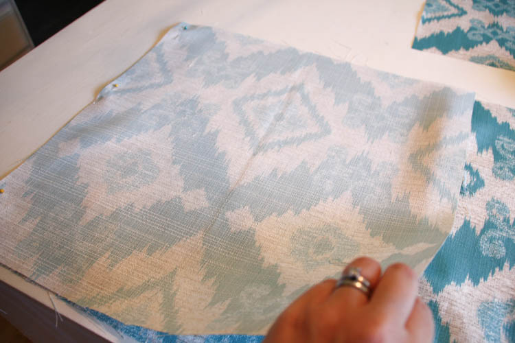 Pinning the next side of the square fabric.