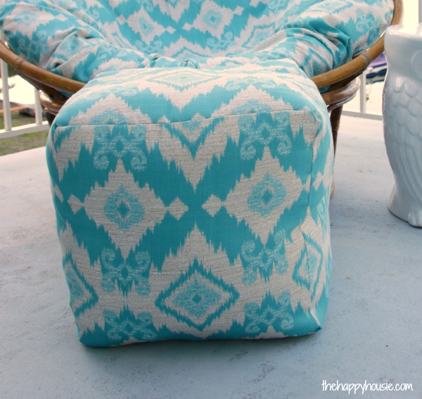 The ottoman square pouf in front of a round chair.
