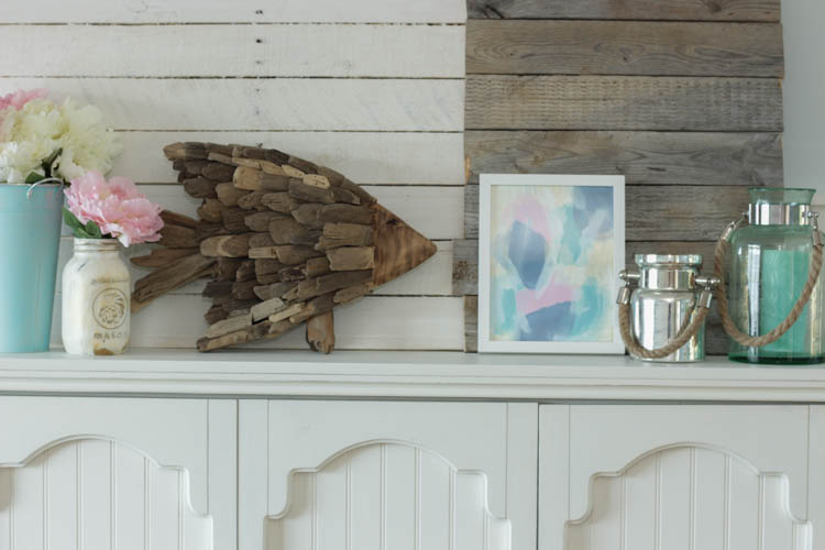 A wooden fish made out of driftwood on the mantel.