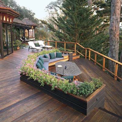 A large wooden deck with a built in sectional couch.