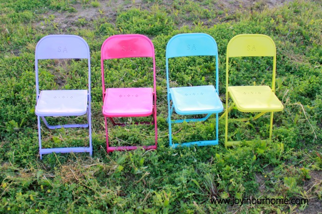 Colorful chairs sitting in the grass.