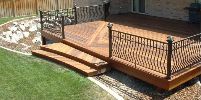 A small wooden deck with wrought iron railing.