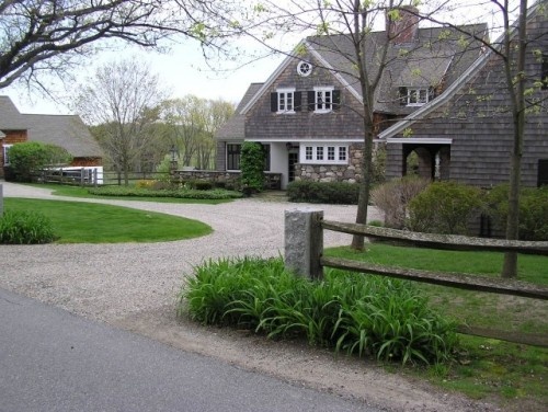 A brown house with white details and a round driveway.