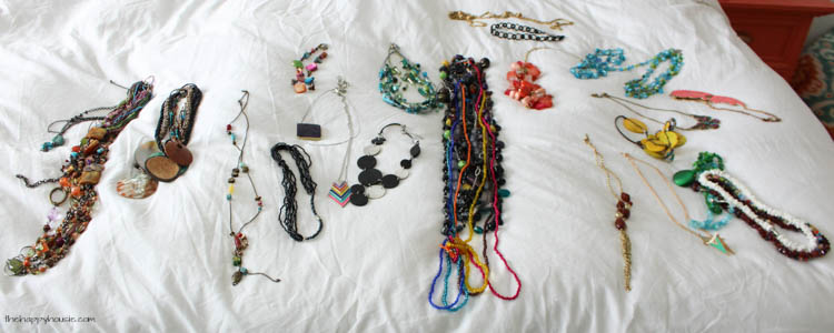 Jewellery laid out on the bed to organize.