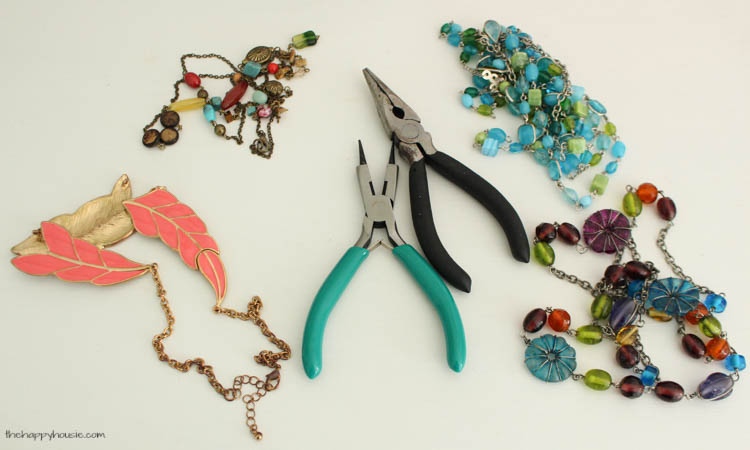 Pliers on the bed beside the necklaces.