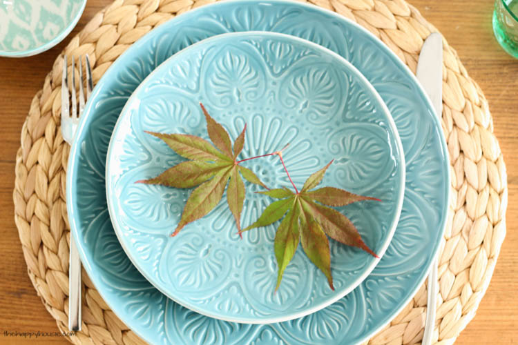 Blue plates with a sprig of fall leaves.