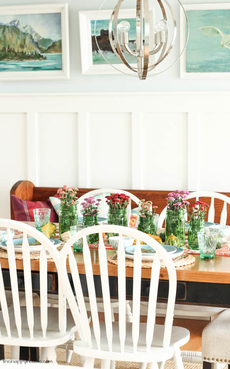 Mason jars that are filled with wildflowers are on the table.
