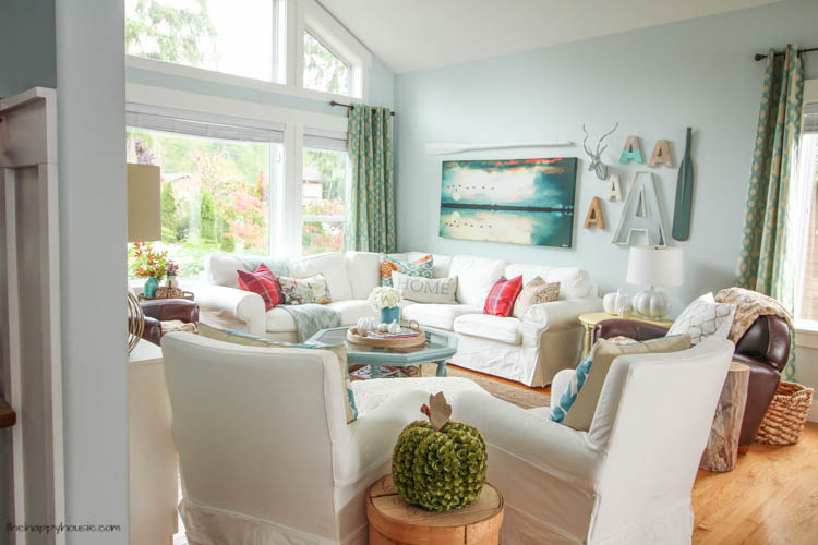 A look into the living room with white furniture and blue accents.