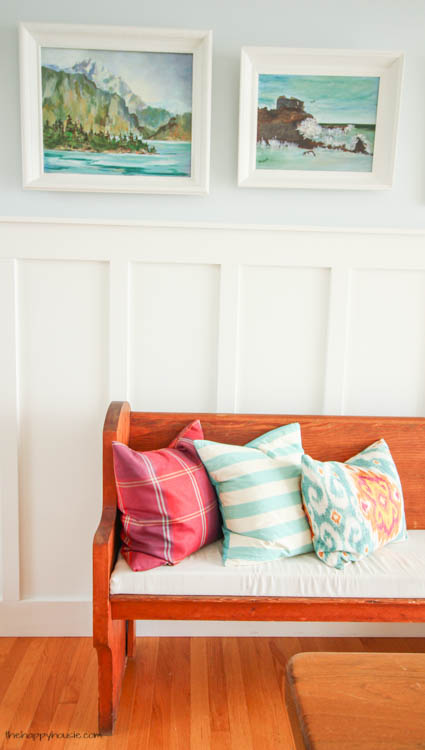 Throw pillows are on the wooden bench.