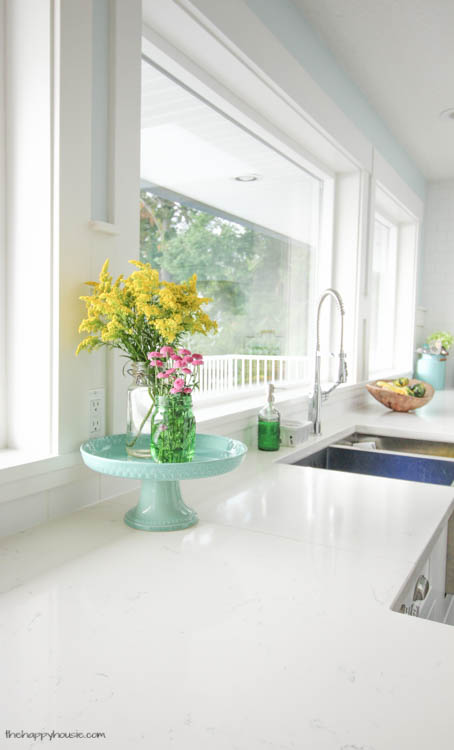 A white kitchen with flowers in it.