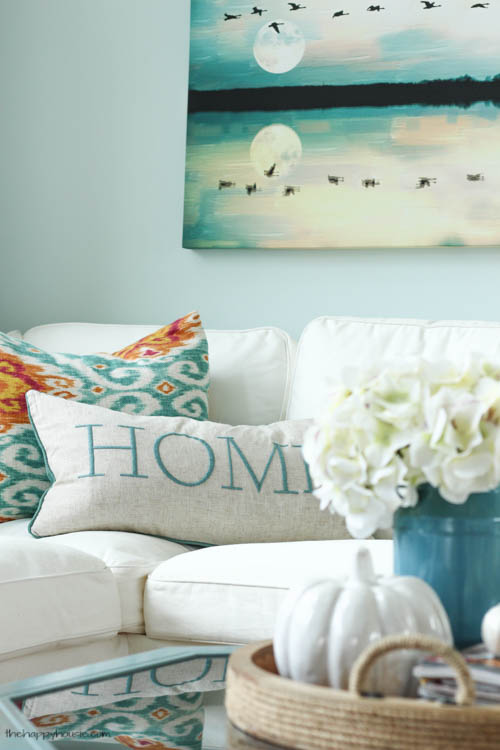 Throw pillow that say home in light blue.