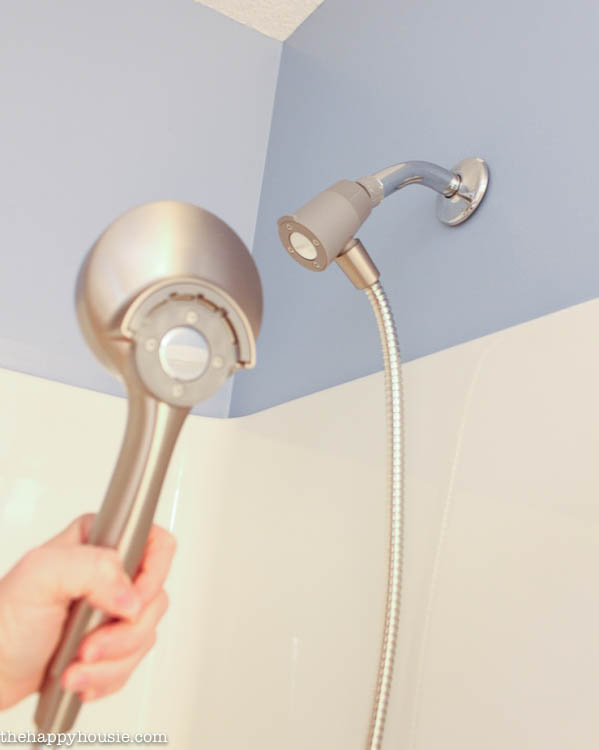 Holding the new shower head.