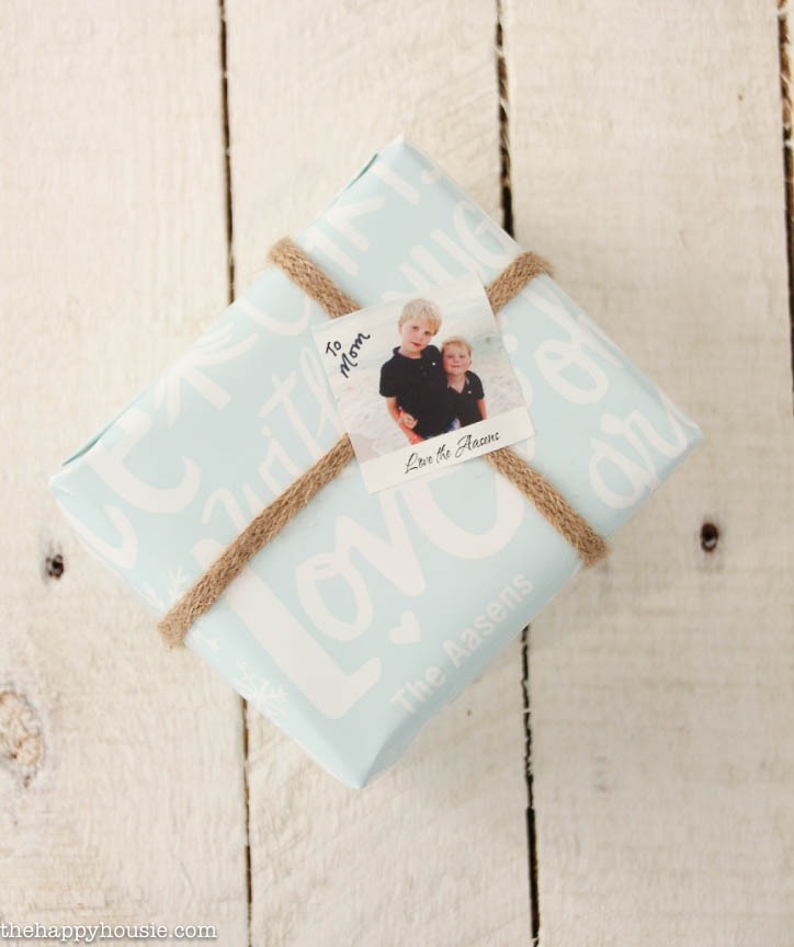A wrapped present with a photo tag of the kids personalizing the present.