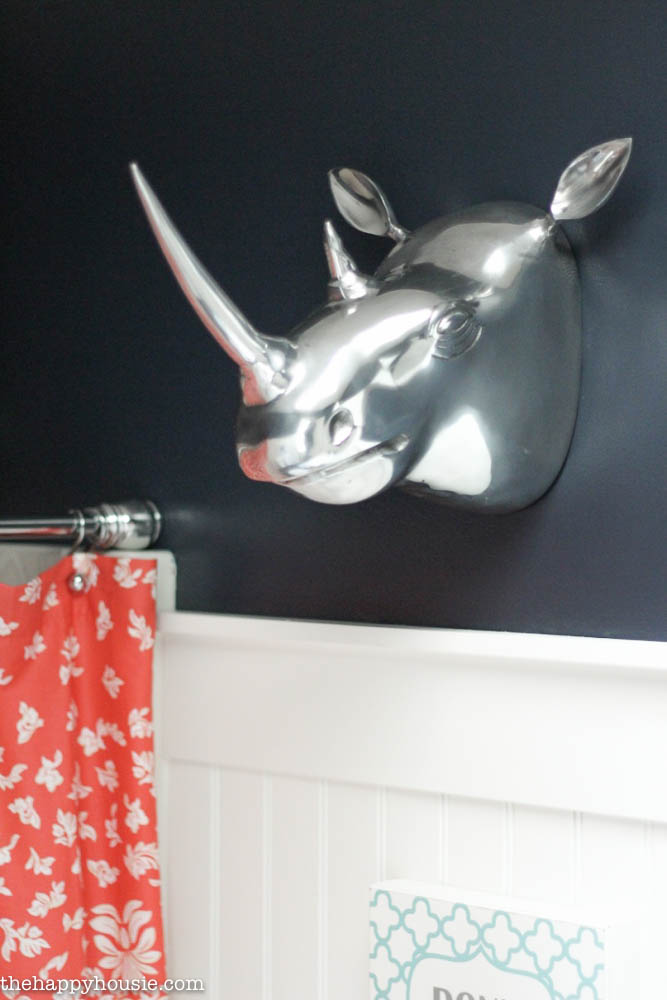 A large silver rhino head is on the wall.