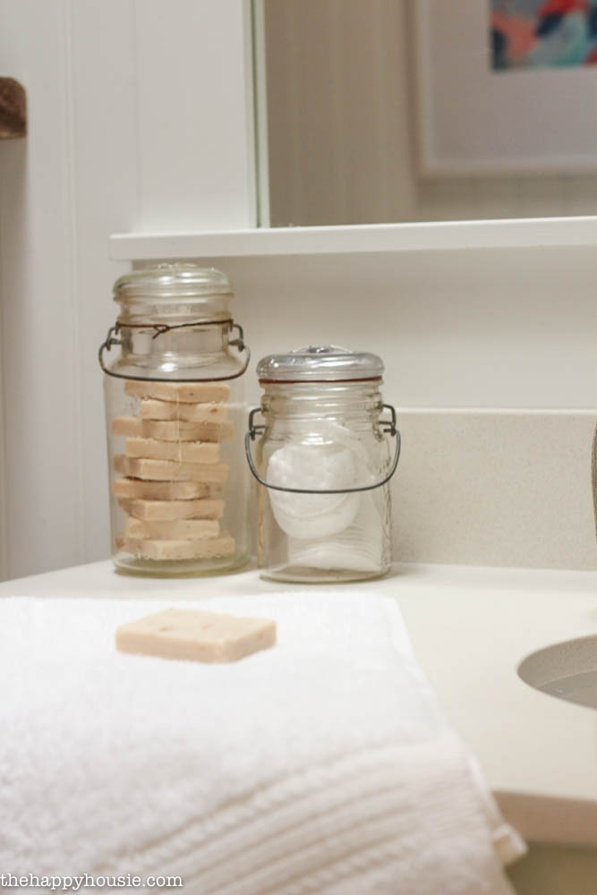 Vintage jars filled with soap is beside the sink.