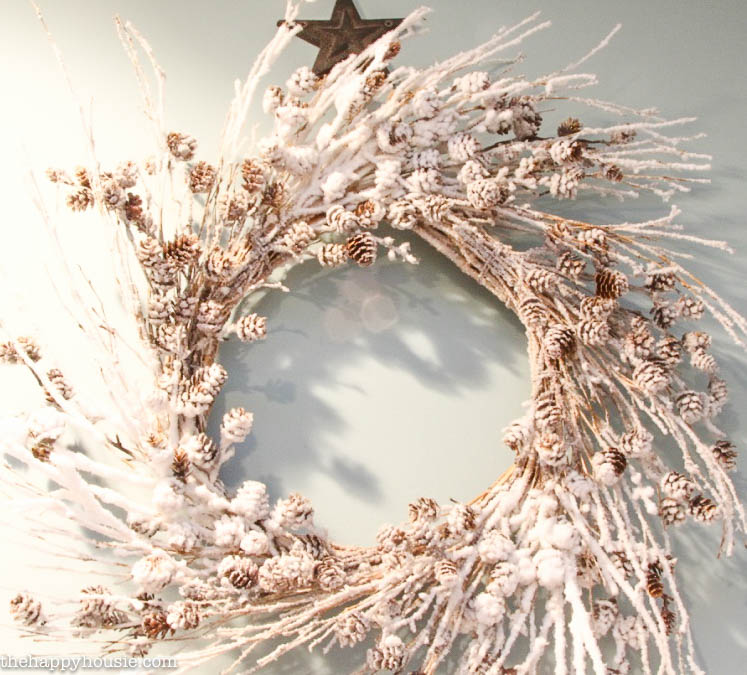 A flocked pinecone wreath on the wall.