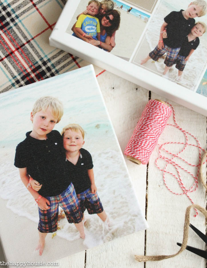 The pictures are on the table beside some red and white string and plaid.