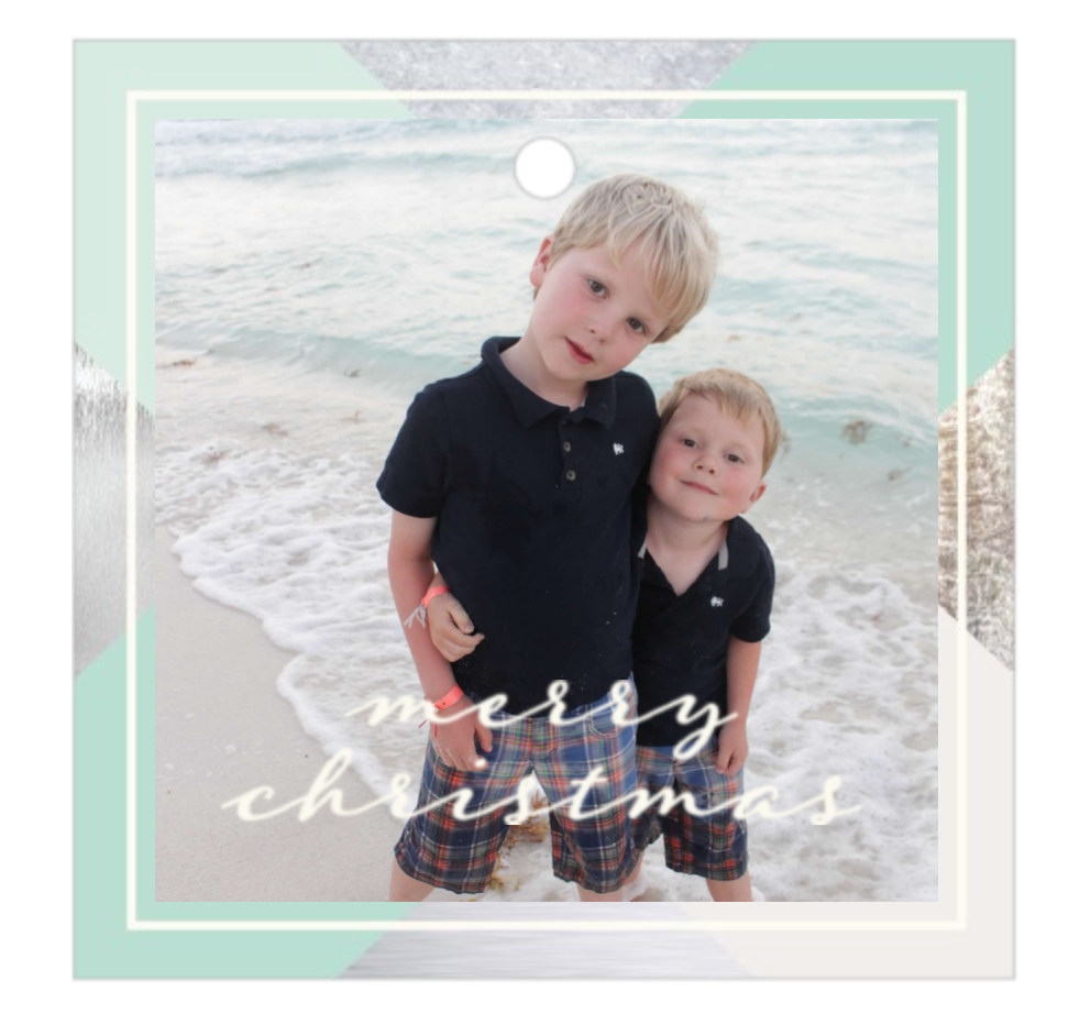 The two boys with Merry Christmas on the picture standing in the beach.