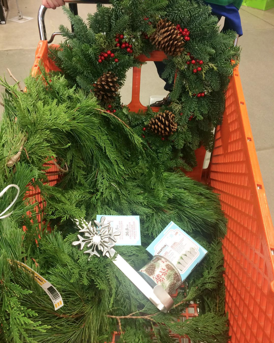 Greenery items like a green wreath in a Home Depot shopping cart.