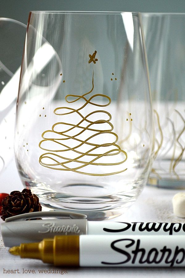 A gold sharpie with a drawing of a Christmas tree and star on a glass.