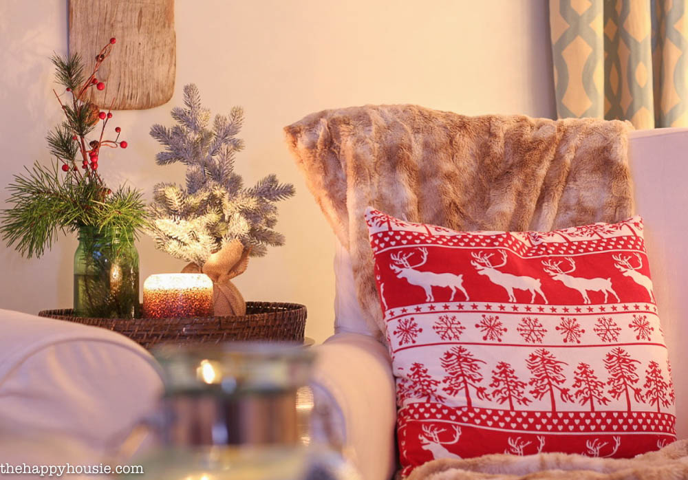 A red and white pillow with antlers on the chair.