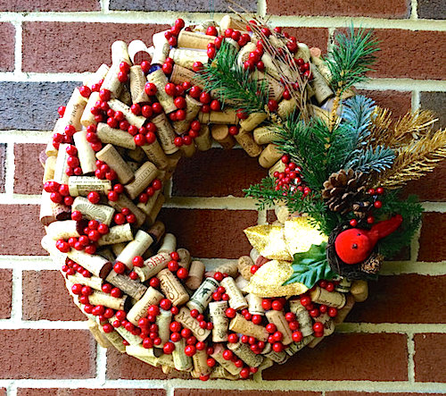 A wreath made up of corks with red berries in between the corks.