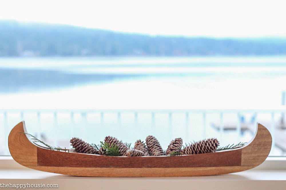 A wooden canoe filled with pine cones.