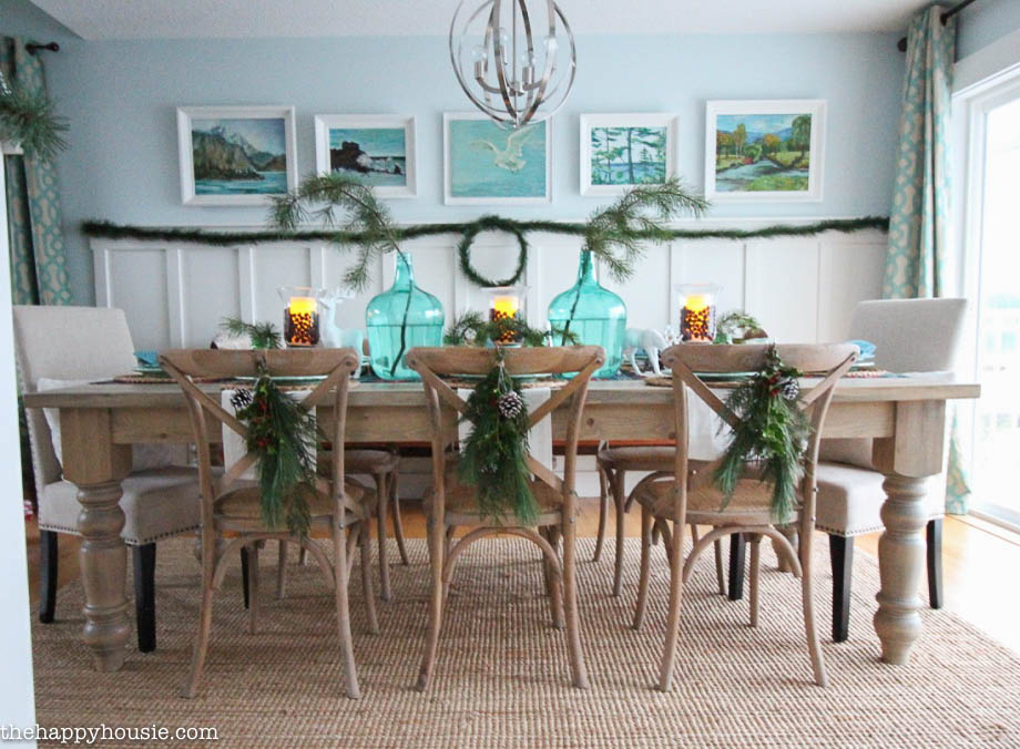 A cottage dining room with a wood table and chairs decorated for Christmas.