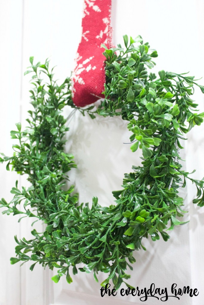 A boxwood wreath with a red ribbon.