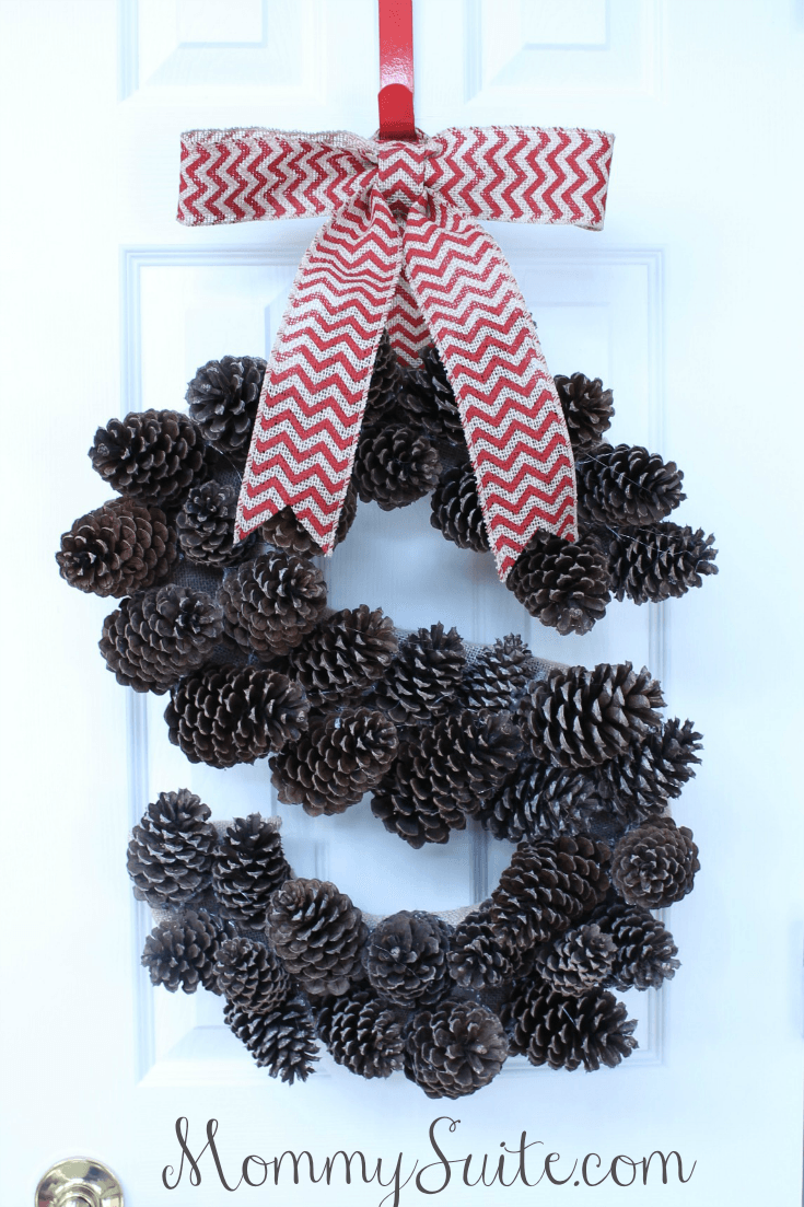 A pinecone wreath and a red and white bow.