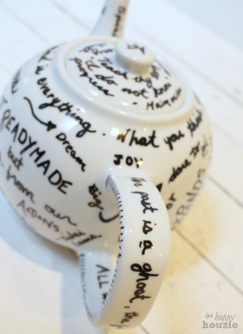 A tea pot with quotes written all over it.
