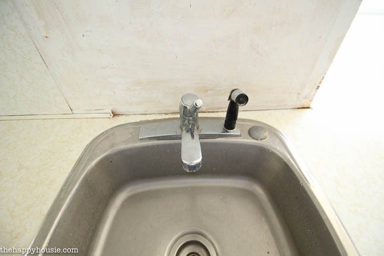An old stainless steel sink and faucet.