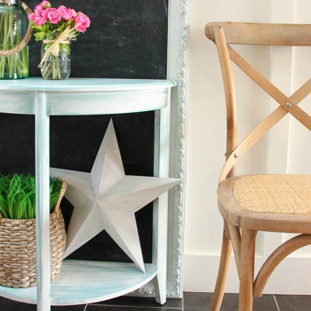 There is small end table with a star on it and flowers.