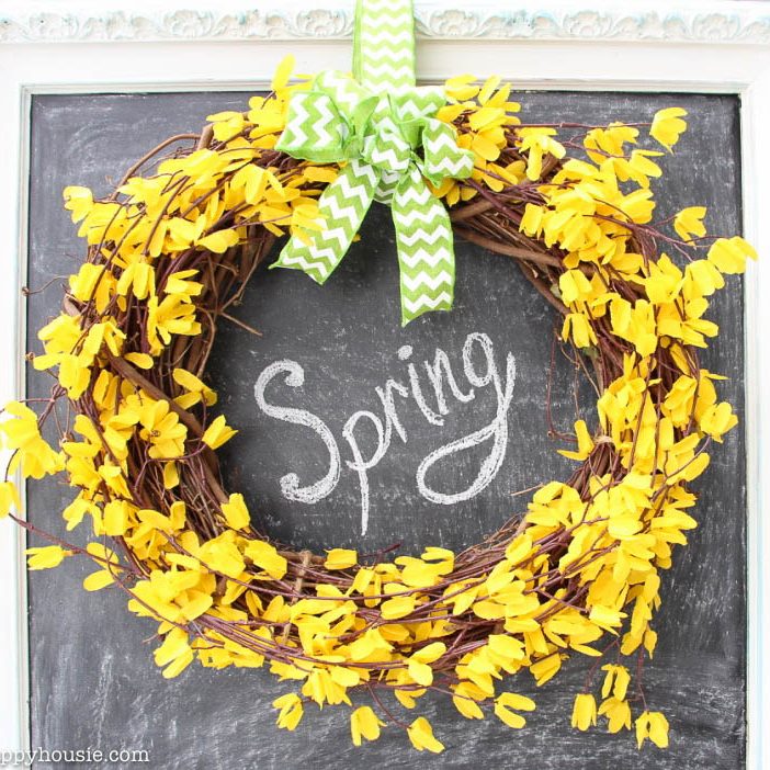 Five Minute Dollar Store Spring Forsythia Wreath hanging on a chalkboard.