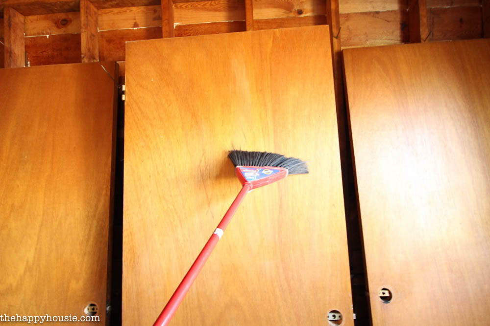 Brushing off the dust on the door with a broom.