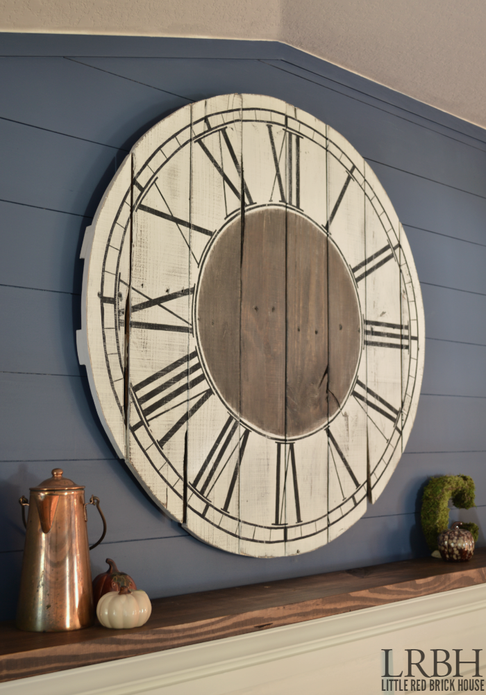 A Roman numeral clock painted on wood on the wall.